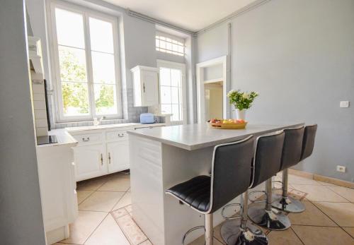 - une cuisine avec un comptoir et quelques chaises dans l'établissement Villa avec piscine et billard, à Sabres