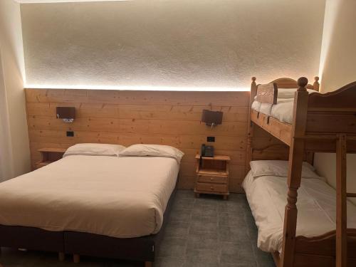 two beds in a room with two bunk beds at Hotel Firenze in Fanano