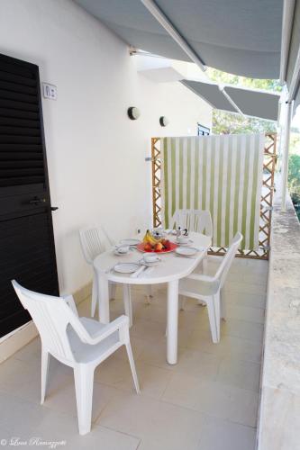 a white table and chairs on a patio at Le Case Bianche in Orosei