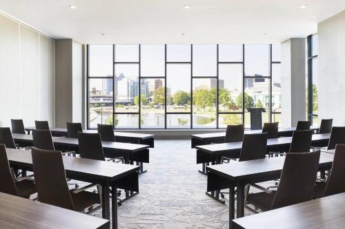a room with tables and chairs and large windows at AC Hotel by Marriott Huntsville Downtown in Huntsville