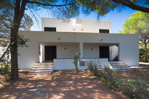 a white house with trees in front of it at Le Case Bianche in Orosei