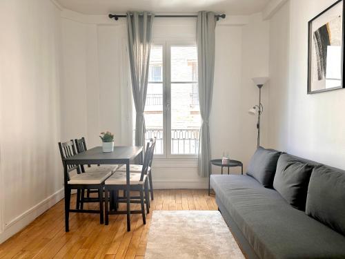 un salon avec un canapé et une table dans l'établissement Spacious flat near Montparnasse Bausset 4th, à Paris