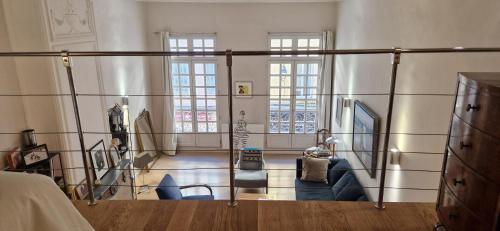 Cette chambre comprend un lit et deux fenêtres. dans l'établissement Loft de charme - centre historique, à Aix-en-Provence