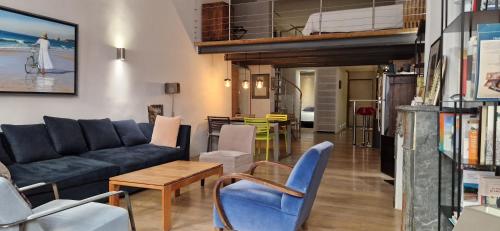 un salon avec un canapé bleu et des chaises dans l'établissement Loft de charme - centre historique, à Aix-en-Provence