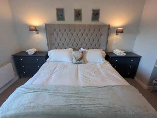 a bedroom with a large bed with two night stands at 4 Beechwood at Thoulstone Park in Westbury