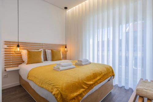 a bedroom with a large bed with towels on it at New Apartment by the Metro - 4E in Lisbon