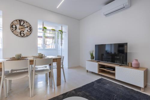 a dining room with a table and a large tv at New Apartment by the Metro - 4E in Lisbon
