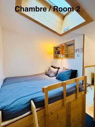 - une chambre avec un lit doté d'un cadre de lit en bois dans l'établissement Le Petit Cham, à Chamonix-Mont-Blanc