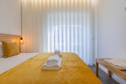 a bedroom with a bed with towels on it at New Apartment by the Metro - 4E in Lisbon