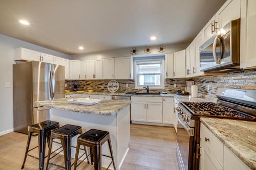 a kitchen with white cabinets and bar stools at 4 Mi to Lake Michigan East Chicago Home with Grill in East Chicago
