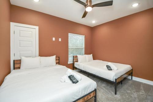 a bedroom with two beds and a ceiling fan at Mount Melanin Spacious 4BD Home Sleeps 17 - Near NRG Stadium in Houston