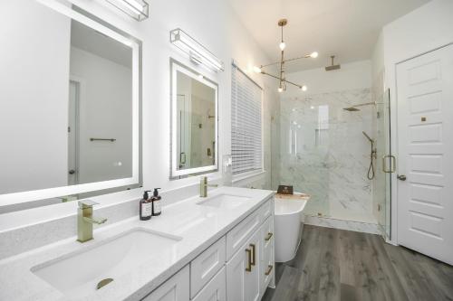 a white bathroom with two sinks and a large mirror at Mount Melanin Spacious 4BD Home Sleeps 17 - Near NRG Stadium in Houston