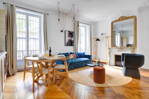 un salon avec une table et un canapé bleu dans l'établissement Bluestay 125 - Superb apartment in Paris, à Paris