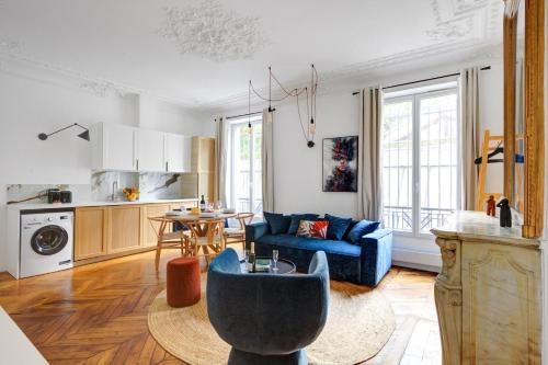 un salon avec un canapé bleu et une cuisine dans l'établissement Bluestay 125 - Superb apartment in Paris, à Paris