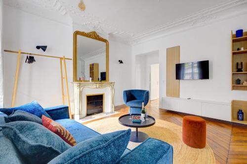 un salon avec un canapé bleu et un miroir dans l'établissement Bluestay 125 - Superb apartment in Paris, à Paris