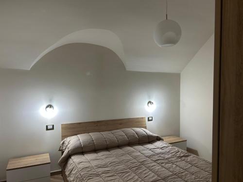 a bedroom with a bed and two lights on the wall at Nolarium in Pescocostanzo