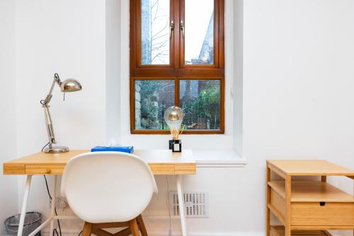 a desk with a white chair and a window at Modern 1 BR Apartment North London in London