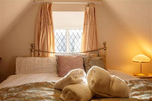 a bed with towels on it with a window at Cute cottage for short getaway in Cross Mahon