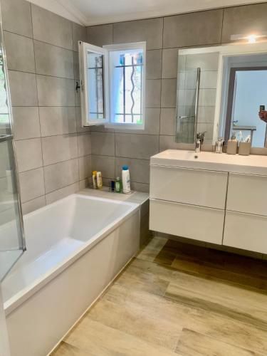 une salle de bain blanche avec une baignoire et un lavabo dans l'établissement THE GREEN OASIS breathtaking view swimming pool privacy in Villa Liliana, à Tourrette-Levens