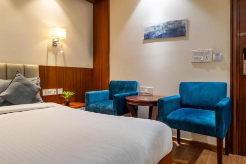 a hotel room with a bed and two chairs and a table at Housr Sector 42 Gurgaon Golf Course Road Near 42-43 Metro Station in Gurgaon