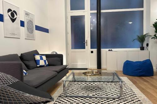 un salon avec un canapé et une table en verre dans l'établissement Cosy T3 in the heart of Popincourt, à Paris