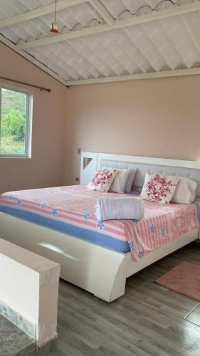 a bedroom with a large bed in a room at Alojamiento en Lago Calima, chalets de montaña con piscina y jacuzzi in Yotoco