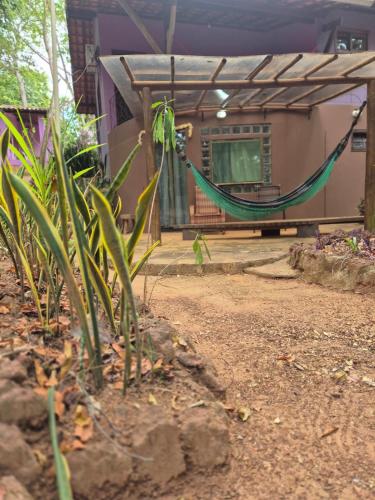 a house with a hammock in front of it at Chalés Ima Teva in Lençóis