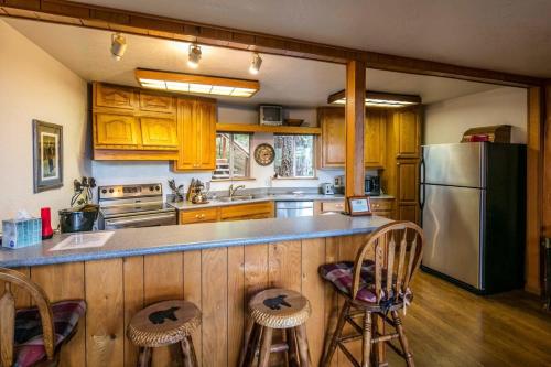 a kitchen with wooden cabinets and a stainless steel refrigerator at Yosemite Cub's Cabin in Yosemite West