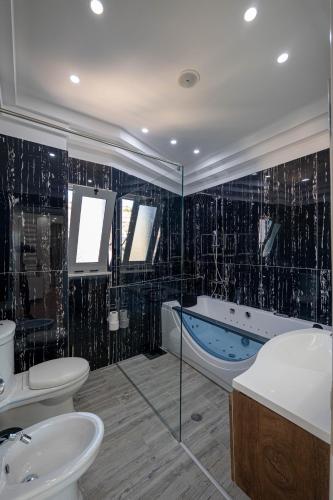ein Badezimmer mit Badewanne, Toilette und Waschbecken in der Unterkunft Summer Dream Penthouse in Sarandë