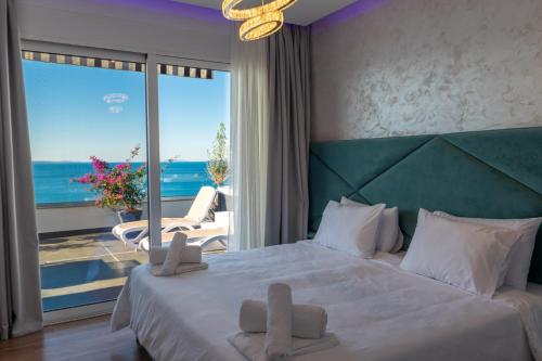 a bedroom with a bed with a view of the ocean at Summer Dream Penthouse in Sarandë
