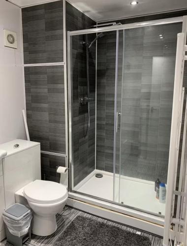 a bathroom with a toilet and a glass shower at 5 BedRm Hse! Ev! & Nr CityCentre! in Manchester
