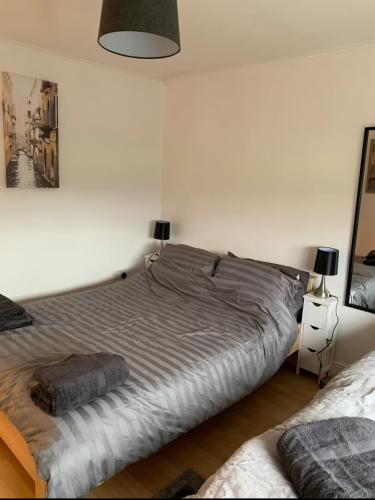 a bed in a white room with a large bed at 5 BedRm Hse! Ev! & Nr CityCentre! in Manchester