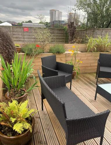 a patio with chairs and tables and potted plants at 5 BedRm Hse! Ev! & Nr CityCentre! in Manchester