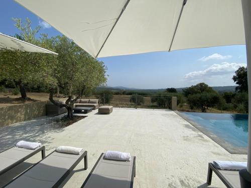une terrasse avec des chaises longues et une piscine dans l'établissement Maison Le Galino- Golfe de Saint Tropez, à La Môle