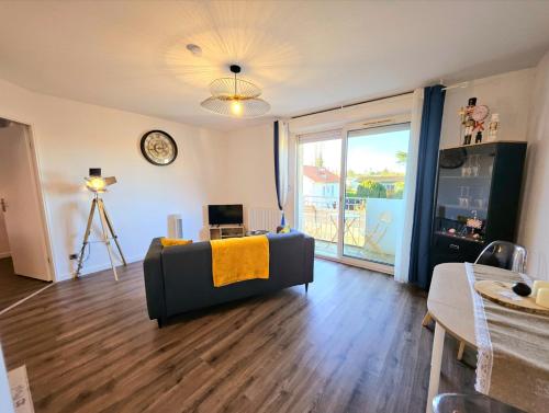 salon z kanapą i zegarem w obiekcie Appartement Résidentiel avec parking/Proche Centre w mieście Angoulême
