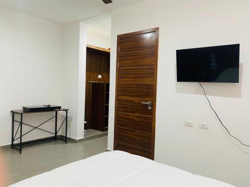 a bedroom with a bed and a television on a wall at Mía Center hotel in Playa del Carmen