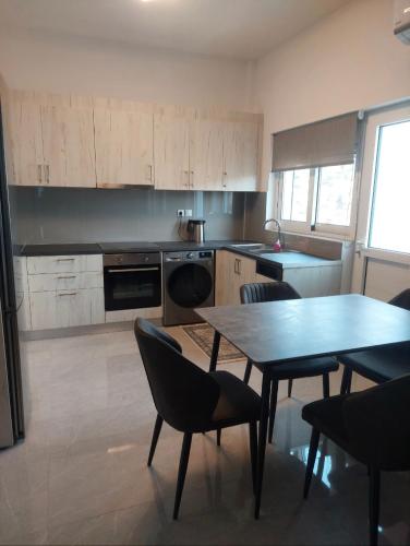 a kitchen with a table and chairs and a table and a table and a kitchen at Euodosi vilia apartments in Vília
