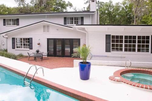 a house with a swimming pool in front of a house at Coaches House - 2 miles from Ben Griffin Stadium in Gainesville