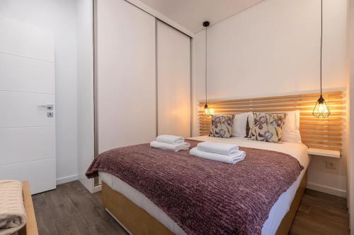 a bedroom with a bed with two towels on it at New Apartment by the Metro - 1E in Lisbon