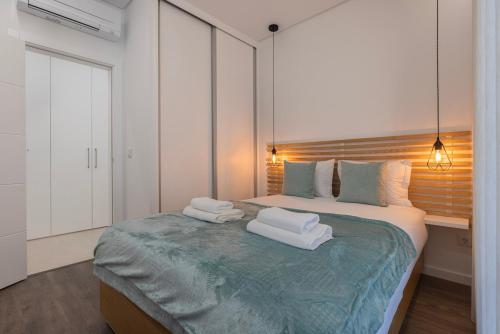 a bedroom with a bed with two towels on it at New Apartment by the Metro - 1E in Lisbon