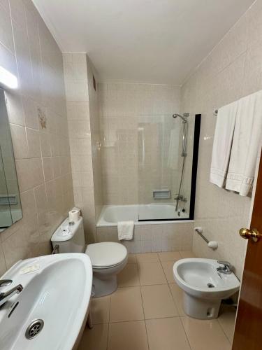 a bathroom with a sink and a toilet and a tub at Hotel Casado in Pas de la Casa