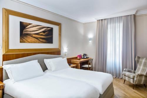 a hotel room with a bed and a chair at Renaissance Naples Hotel Mediterraneo in Naples