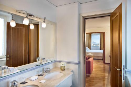 a bathroom with two sinks and a large mirror at Renaissance Naples Hotel Mediterraneo in Naples