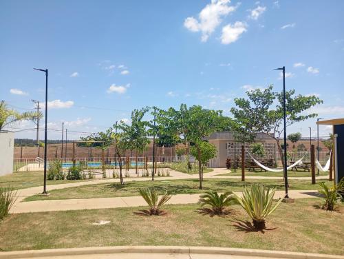 a park with a playground with trees and swings at Apto em frente Beach Clube região privilegiada in Araraquara