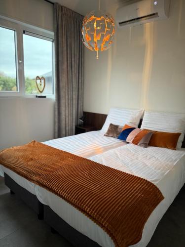a bedroom with a large bed and a chandelier at Sunset Lodge in Lutten