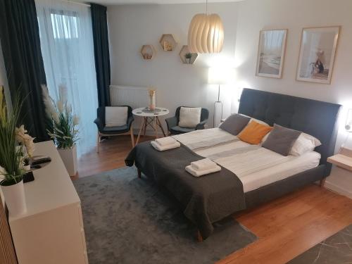a bedroom with a bed and a living room at PINEA Apartament z widokiem na morze z basenem i SPA przy plaży in Pobierowo