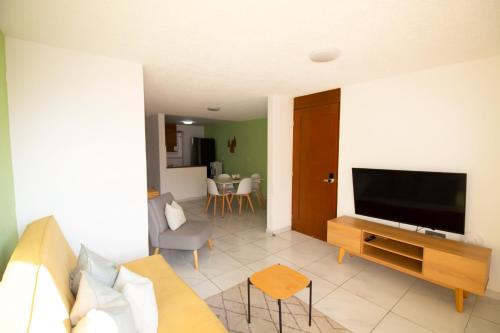a living room with a couch and a flat screen tv at Bonitos departamentos frente a la Expo Guadalajara in Guadalajara