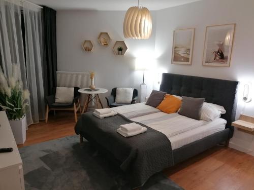 a bedroom with a bed and a living room at PINEA Apartament z widokiem na morze z basenem i SPA przy plaży in Pobierowo