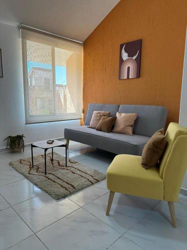 a living room with a couch and a chair at Bonitos departamentos frente a la Expo Guadalajara in Guadalajara