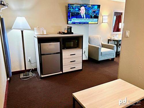 a hotel room with a tv and a chair at Travel Inn & Suites Flemington in Flemington